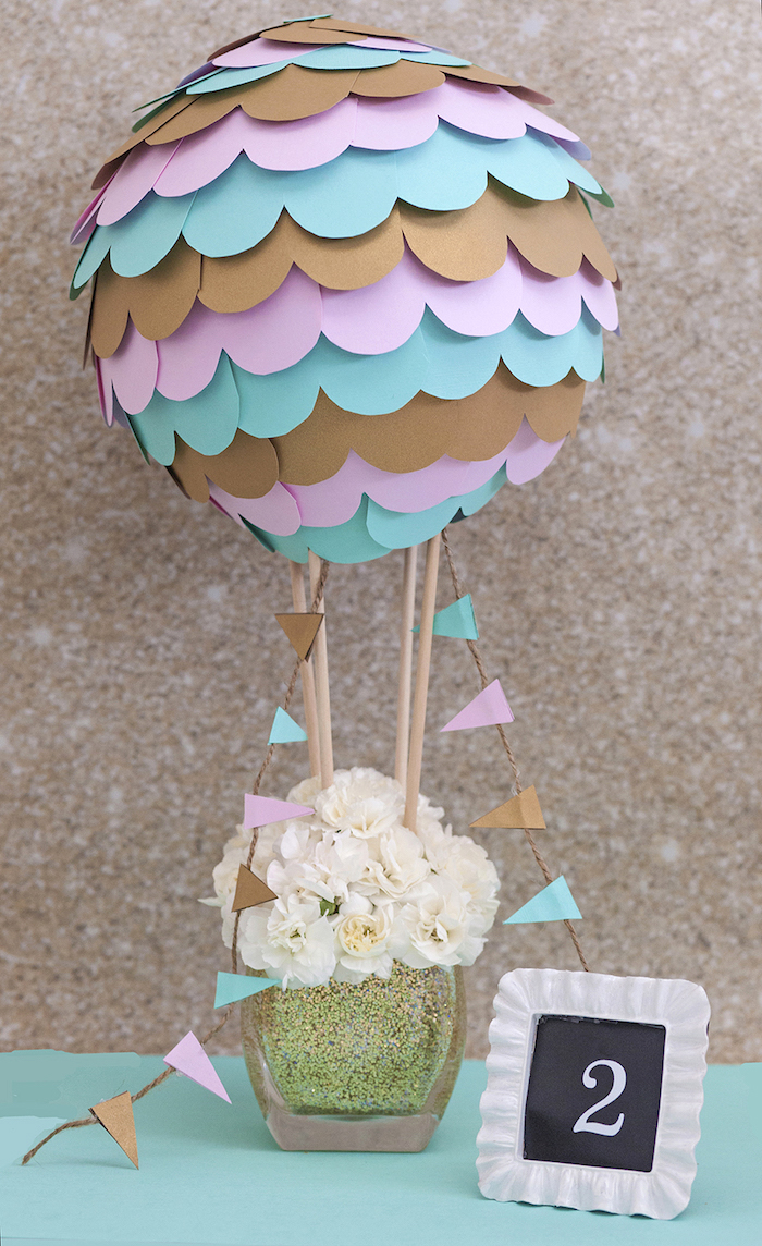pappmache luftballon dekoriert mit buntem bastelpapier, weiße blumen in glasvase, tischdeko