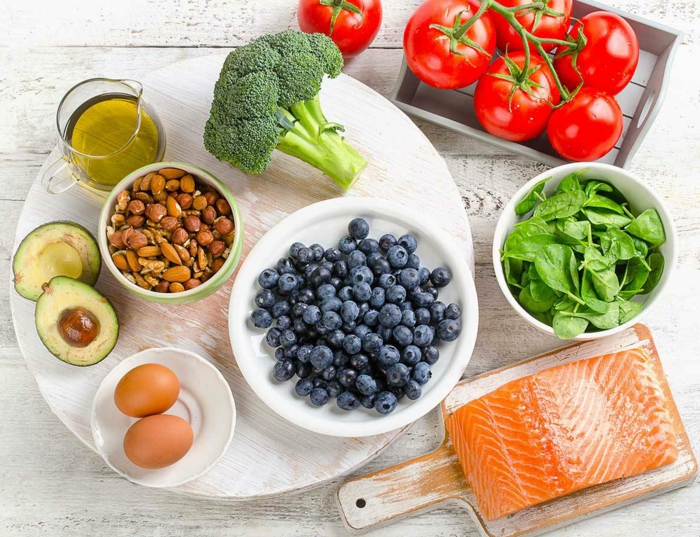 10 regeln der dge, gesundes essen selber kochen, lachs mit salat aus spinat, tomaten, avocado, eier und mandeln, brokkoli als beilage und blaubeeren zum nachtisch