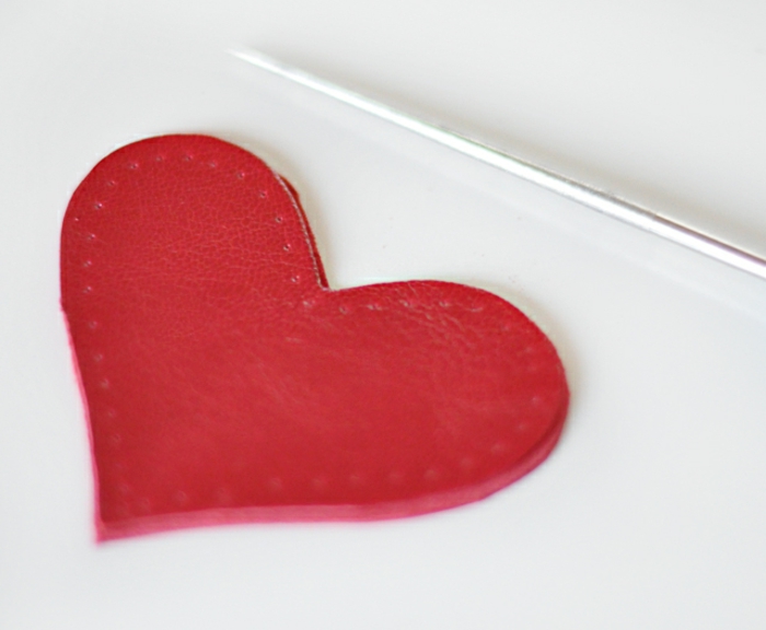 ein rotes Herz mit Ahle perforiert, damit Sie die Fäden einfädeln können, Schlüsselanhänger selber machen