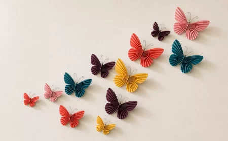 Schmetterling basteln: Papierschwarm mit abstehenden Flügeln an heller Wand
