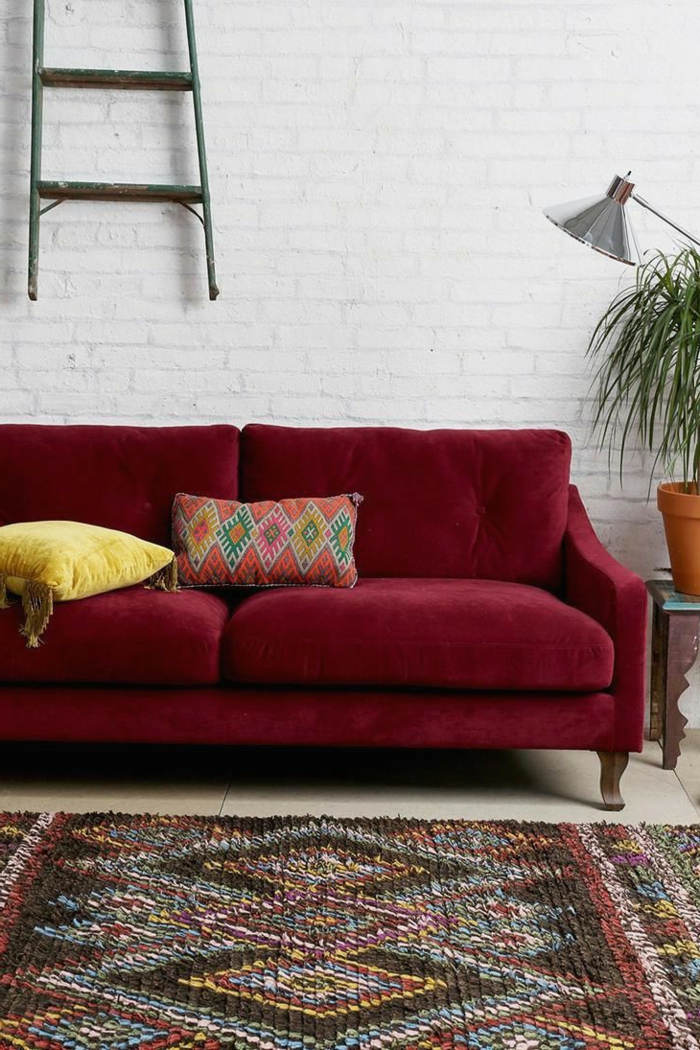 Bordeauxrotes Sofa, weiße Wand, bunter Teppich, welche Farbe passt zu Bordeauxrot