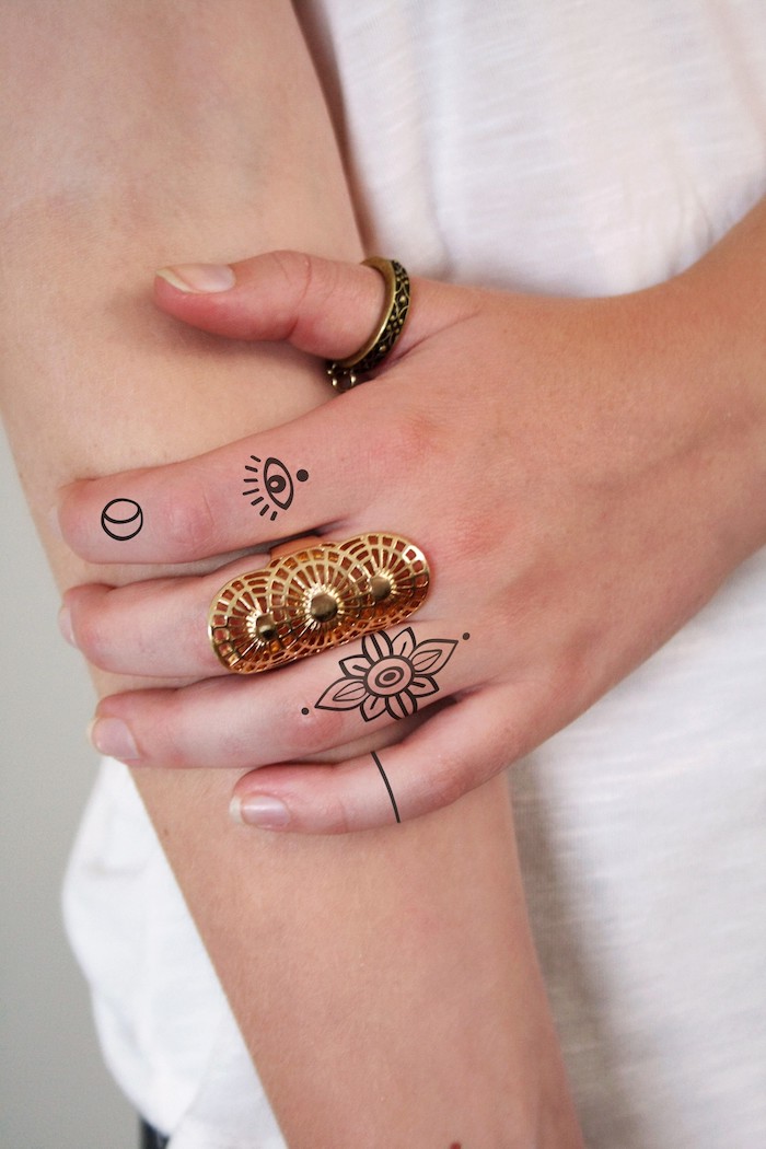 Ideen für Frauen Tattoos am Finger, Mandala Blume am Ringfinger, Auge am Zeigefinger, goldene Ringe