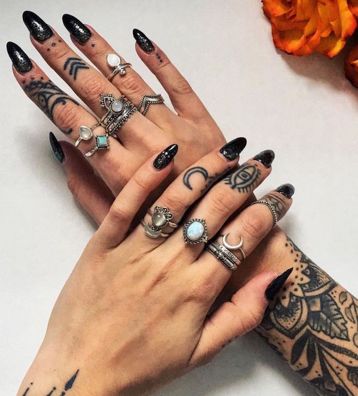 Arm Tattoos Ideen, Tattoo an jedem Finger, viele silberne Ringe, schwarzer Nagellack mit Glitzer