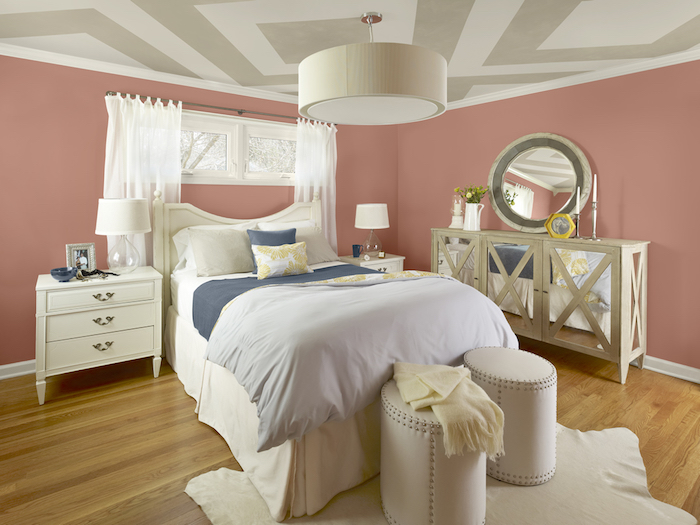 schlafzimmer mit einem bett mit kleinen weißen und grauen kissen und ein bruner boden aus holz, schlafzimmer einrichten, ein schlafzimmer mit pinken wänden