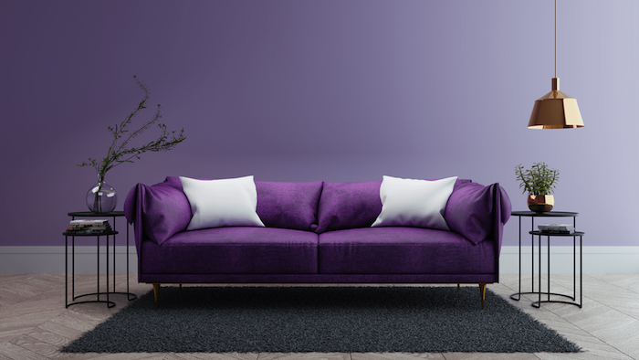 schwarzer teppich und ein wohnzimmer mit violetten wänden und einem violetten sofa mit weißen und violetten kissen und eine lampe, wandfarbe wohnzimmer