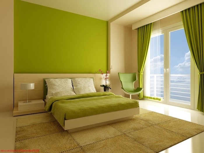 große grüne wand und ein bett mit einer grünen decke und großen kissen und ein grüner stuhl, ein fenster mit einem grünen vorhang, wandfarbe grün