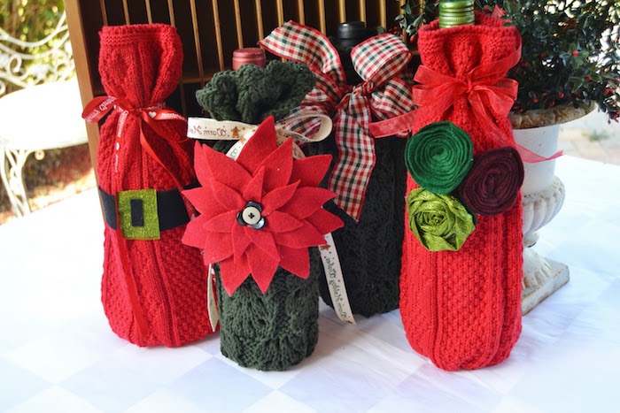 kleine rote flaschen mit grünen und roten blzmen und mit roten schleifen, eine weihnachtsdeko selber basteln ideen, upcycling diy