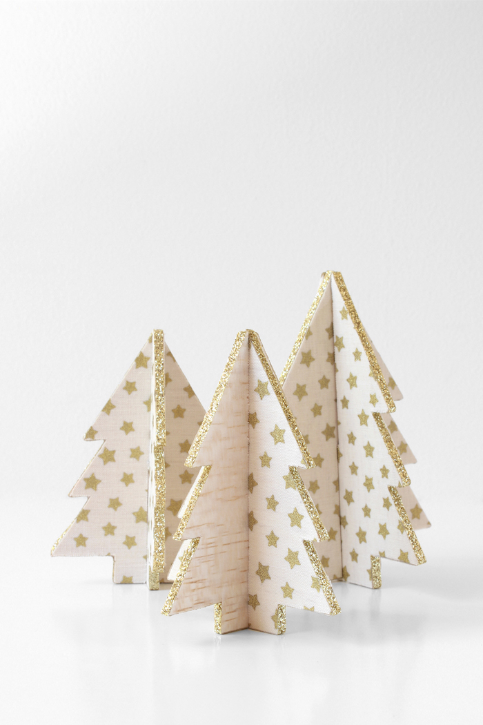winterdeko basteln, tannenbäume aus holz dekoriert mit weißem stoff mit goldenen sternen