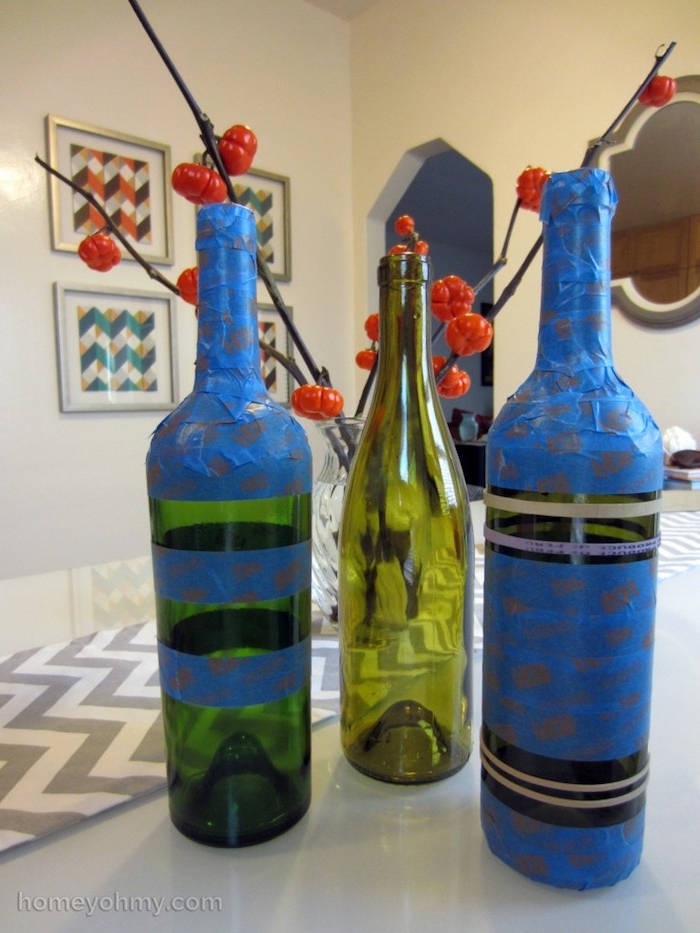 eine tischdekoration mit zwei blauen alten weinflaschen und mit einer grünen flasche aus glas, vasen aus flaschen selber machen