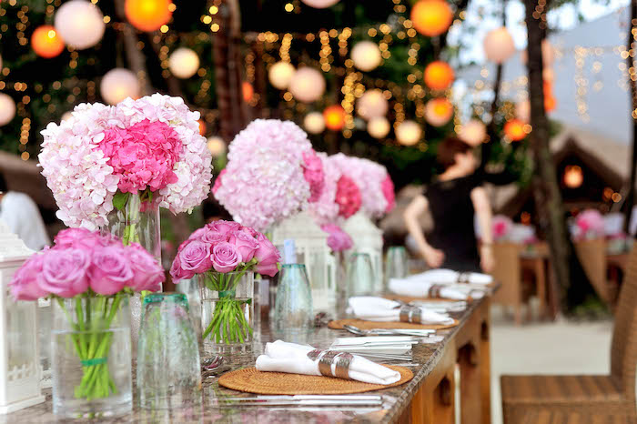 hochzeitstischdeko für hochzeit im sommer, glasvasen mit rosen, rosa hortensieren, lichterketten