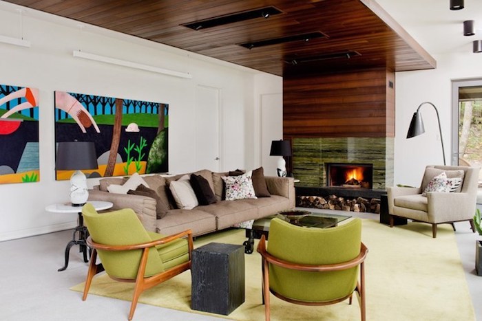 wandgestaltung wohnzimmer ideen mit krassen farben, wandbilder, bunte bilder, grüne sessel, kamin, beiges sofa