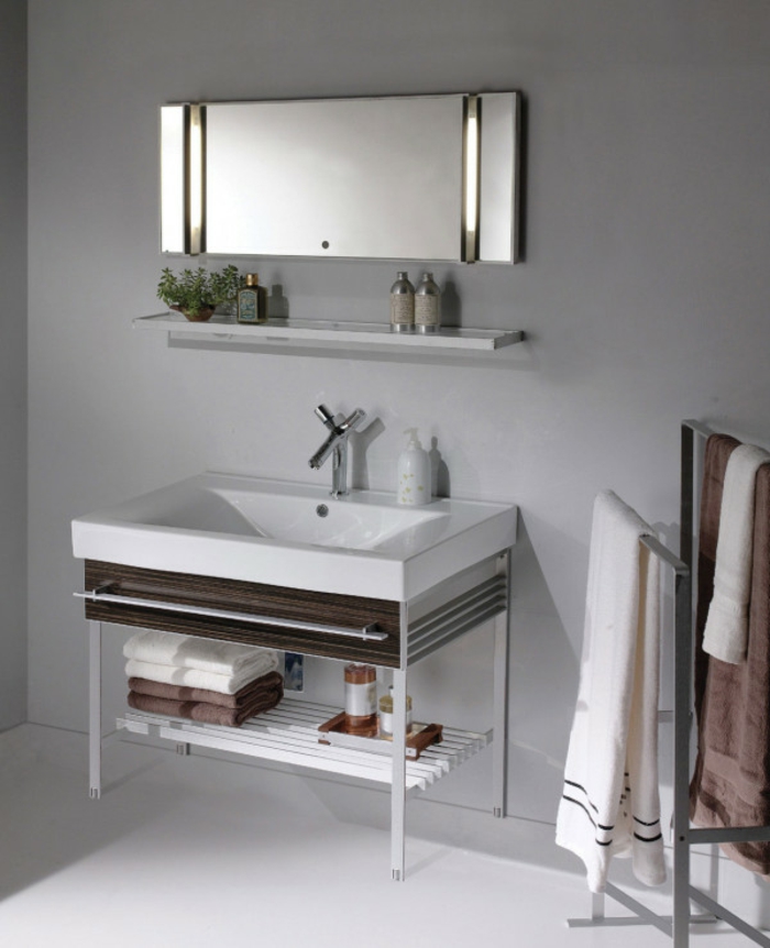 ein länglicher Spiegel, eine Leiste mit kleinen Dekorationen, schöne Badezimmer, ein weißer Waschbecken