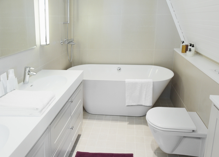 schöne Badezimmer in einer Dachwohnung, kleine Fliesen in weißer Farbe am Boden, ausgelassene Badewanne
