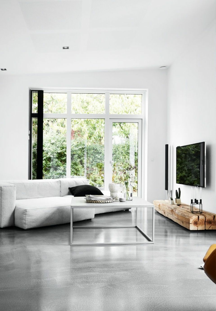 ein modernes Wohnzimmer, weißes Sofa, ein weißer Tisch, Fußboden Betonoptik, große Fenster