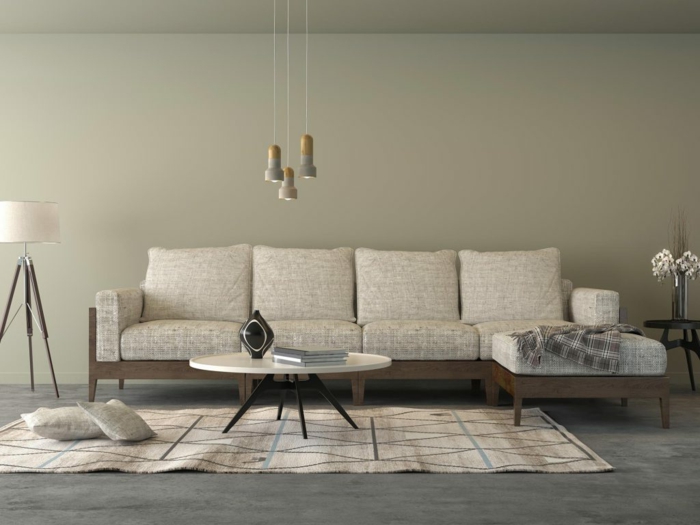graue Wände, ein graues Sofa, ein weißer Teppich, ein runder Tisch, Pendelleuchte, graue Betonbodenfarbe
