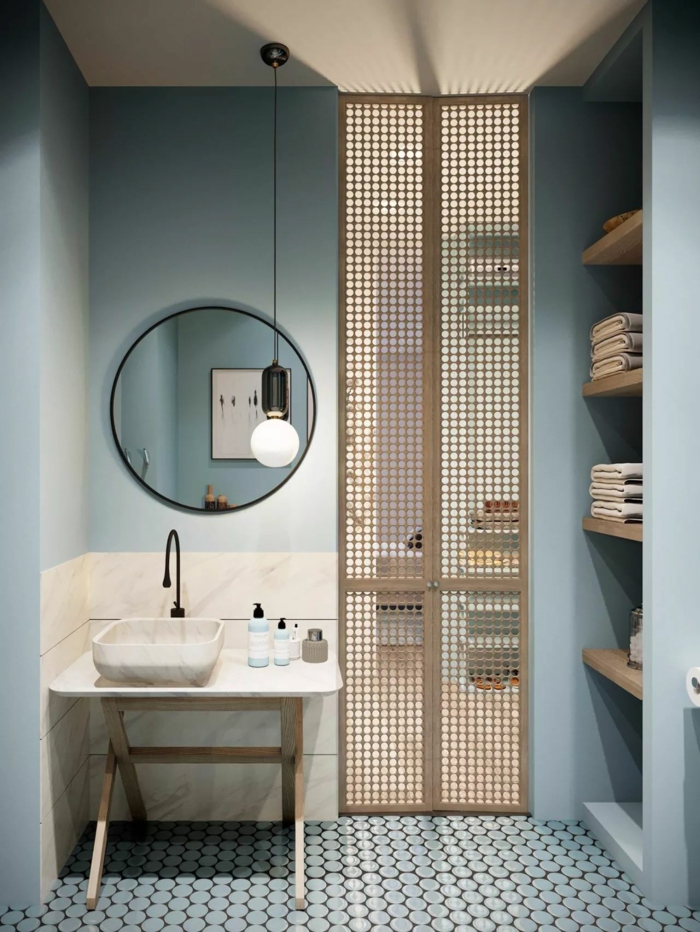 blaue Wände, ein runder Spiegel, kleine Mosaikfliesen, kleiner Abstelltisch mit Waschbecken, Badezimmer Ideen für kleine Bäder