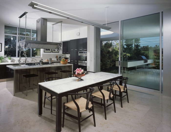 Esszimmer und offene Küche, Bodenbelag Betonoptik, Tisch in schwarz weiß und sechs Stühle