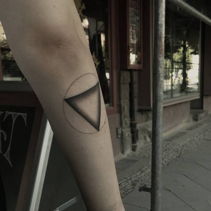 tattoo ideen für männer, eine hand mit einem kleinen schwarzen tattoo mit einem schwarzen dreieck und mit einem kreis, geometrische tattoos ideen