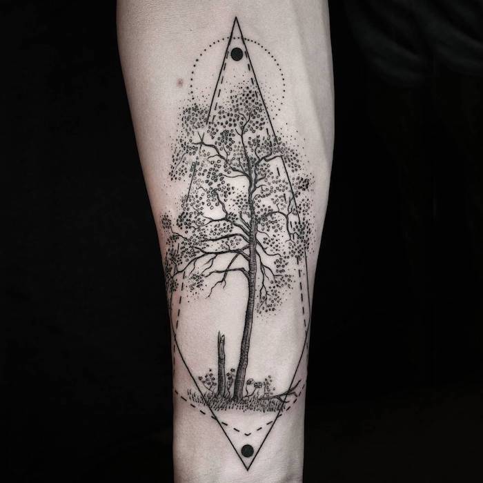 eine hand mit einem großen schwarzen tattoo mit einem schwarzen baum mit schwarzen blättern, grass und, eine sonne und mond, geometrische tattoos ideen