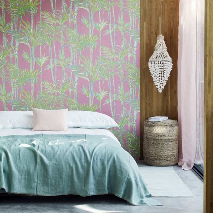 ein modernes Schlafzimmer, eine hängende Lampe, ein blauer Teppich, Fototapete in rosa und grüner Farbe, Fußboden Betonoptik