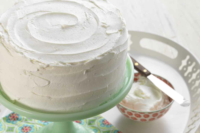 schneller Kuchen mit weißen Vanillie Creme dekoriert mithilfe eines kleinen Messers