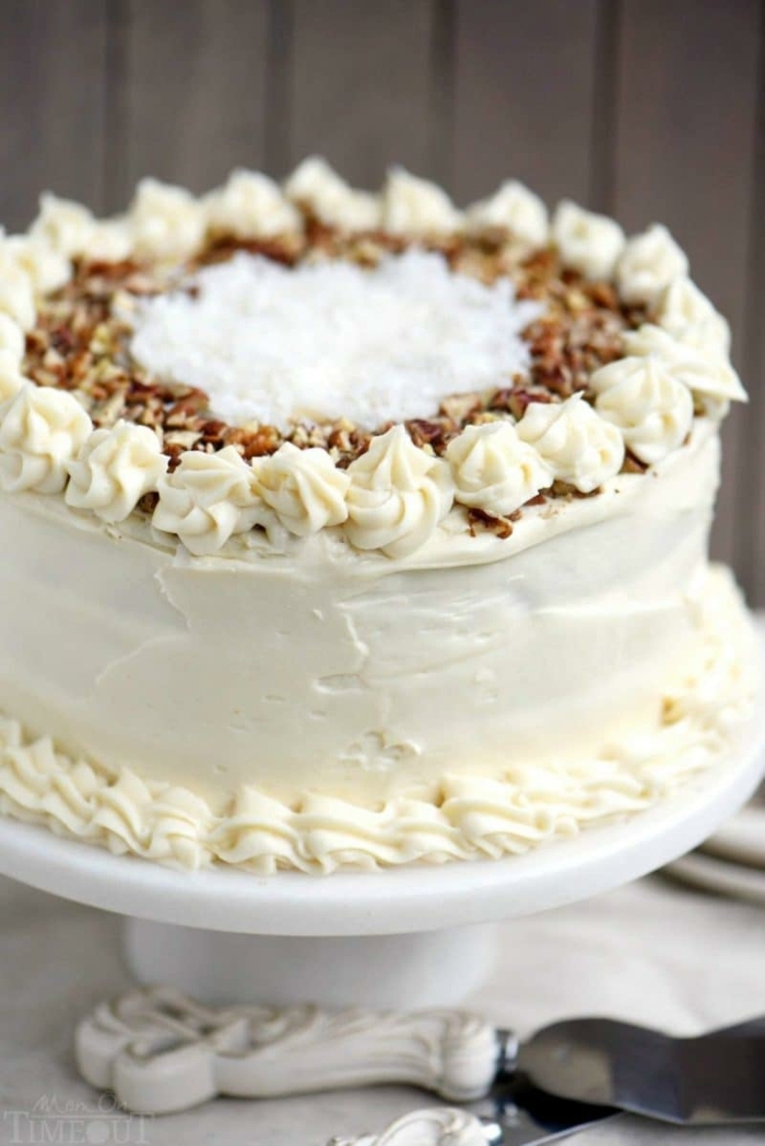 Torte mit weißer Creme, mit zerkrümelte Nüssen bestreut, Kokosraspeln in der Mitte, schneller Kuchen
