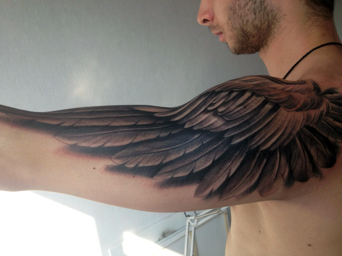 mann mit 3d tätowierung, engelsflügel tattoo arm, schwarz grau, realitisch