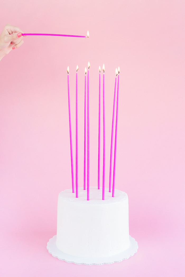 Geburtstagstorte mit weißer Glasur, hohe violette Kerzen, Geburtstag für Mädchen planen