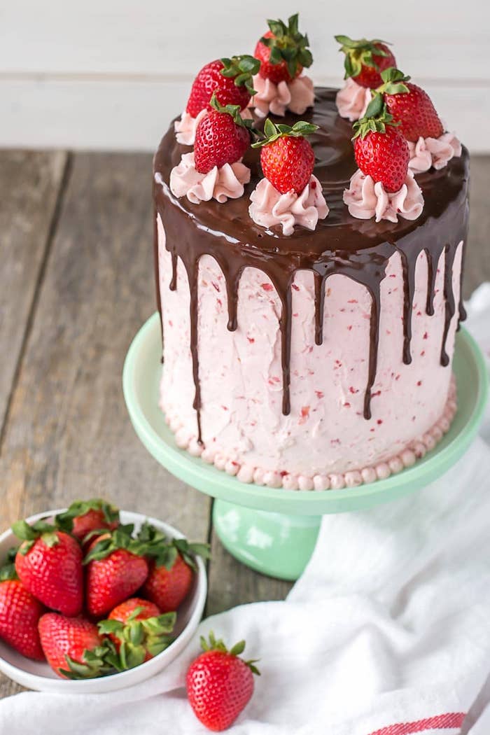 Dreistöckige Torte mit Erdbeercreme und Schokoladenglasur, mit frischen Erdbeeren dekoriert
