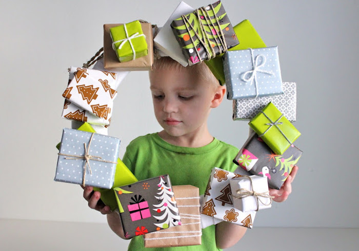 geschenkbox weihnachten, kleiner junge, weihanchtskranz aus geschenkboxen