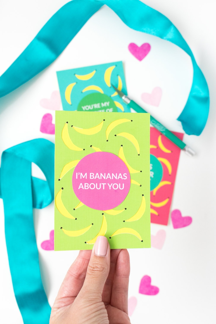 eine grüne Karte mit rosa Aufkleber, kleine Figuren von Bananas, Geschenke verpacken