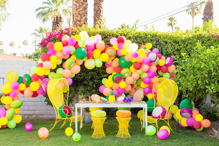 Gartenparty organisieren, Bogen aus bunten Ballons, Früchte aus Styropor auf dem Tisch