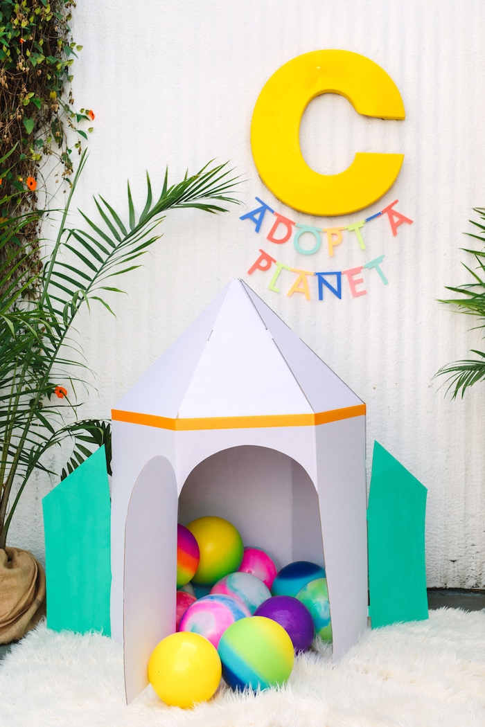 Lustige Spiele für Kindergeburtstag, Zelt aus Pappkarton in Form von Rakete, viele bunte Bälle darin