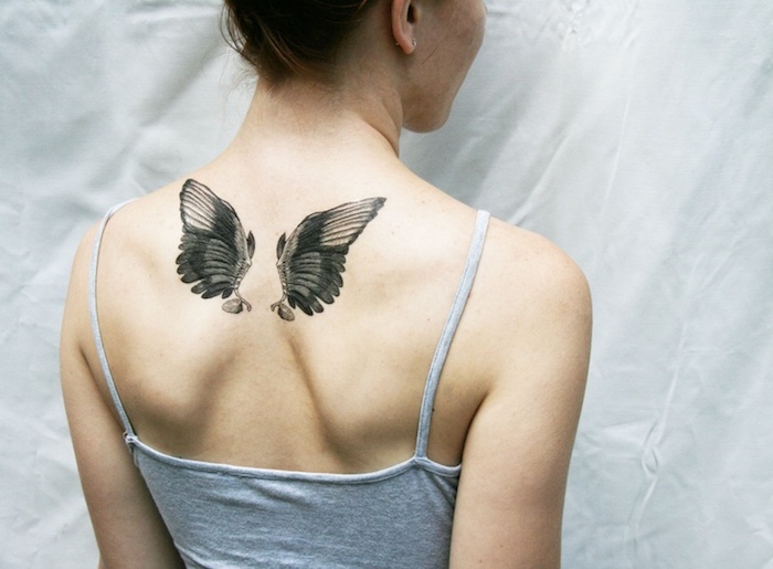 kleine engel tattoos für frauen, zwei flügel am rücken, tätoiwerung in schwarz und grau