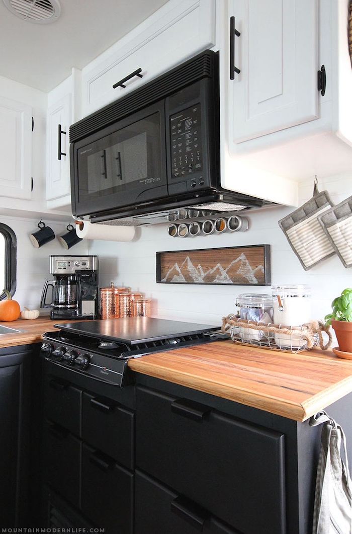 kleine küche einrichten in schwarz und weiß mit hölzernen effekten, mikrowelle an der wand