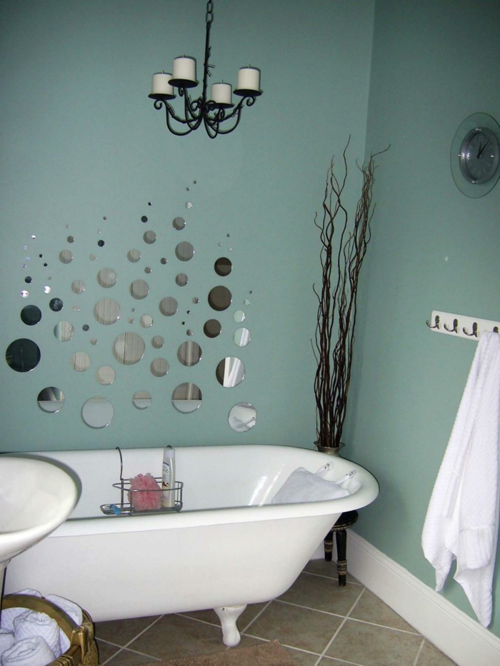 grüne Wände, kleine Spiegel mit gerundeter Form, eine weiße Wanne, trockene Blume in der Ecke