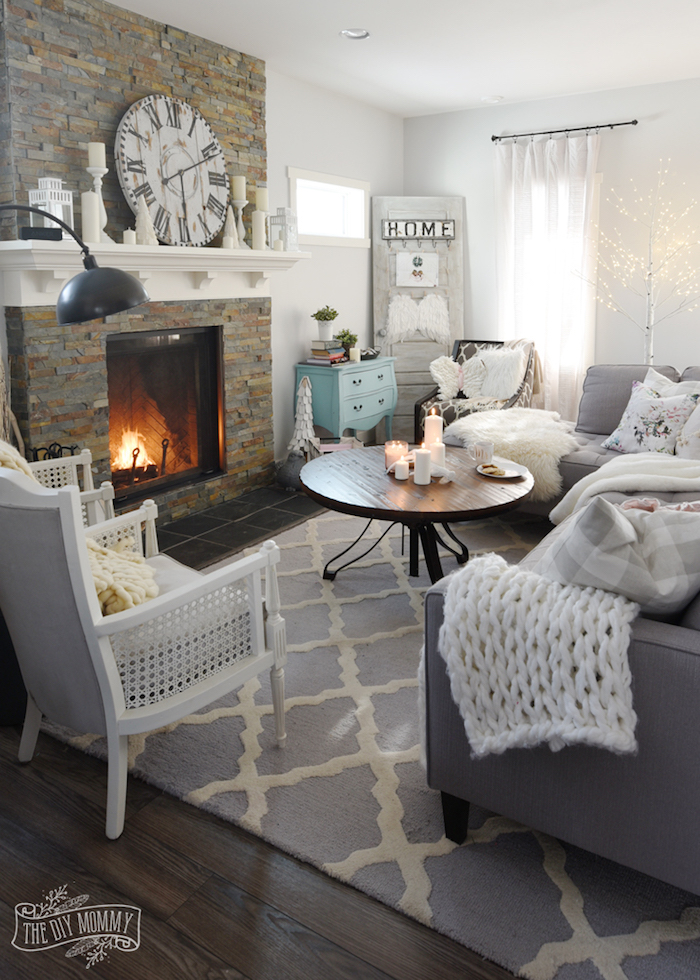 bild von einem wohnzimmer ideen zum nachmachen im skandinavischen design, weiße decken und deko, graue möbel, kamin, dezente einrichtung