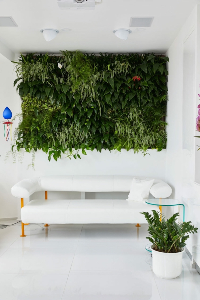 wohnzimmer dekorieren ideen, grüne wand voll von pflanzen, grüne pflanze in topf, weißes sofa