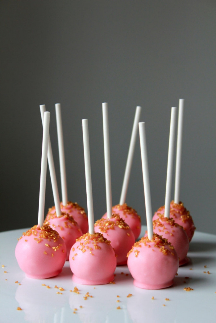 partyrezepte zum vorbereiten, cacke popps mit tortenboden mit schokolade dekoriert mit rosa glasur und zuckerperlen