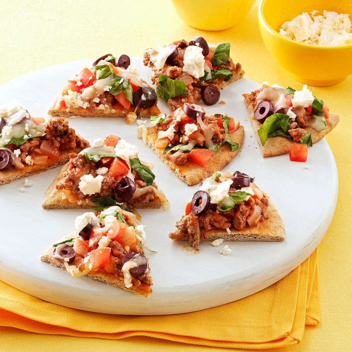 picknick rezepte fingerfood, mini pizzas mit weißem käse, oliven, fleisch und tomaten
