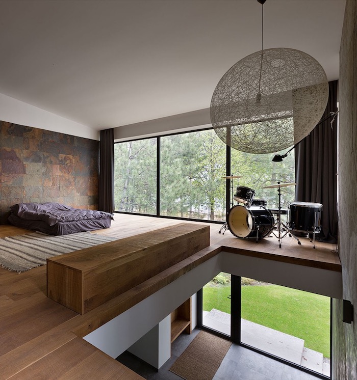 schlafzimmer ideen, minimalistische einrichtung, lila bettwäsche, runde pendellecuhte, wand dekoriert mit natursteinfliesen