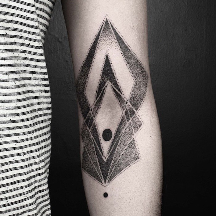 hand mit einem schwarzen totenkopf tattoo mit geometrischen formen, schwarzen kreisen und zwei langen schwarzen hörnern, tattoo motive