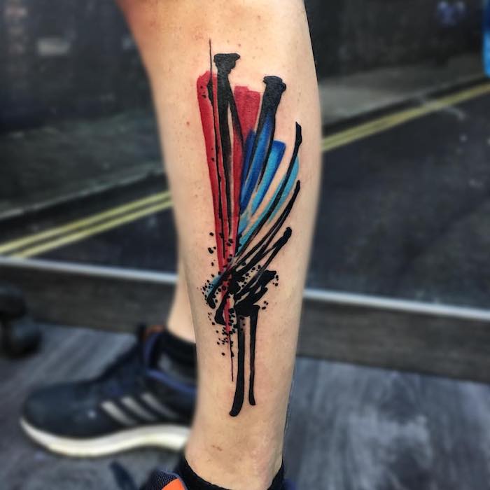 tattoo flügel, schwarze sportschuhe, abstrakte tätowierung in schwarz, rot und blau