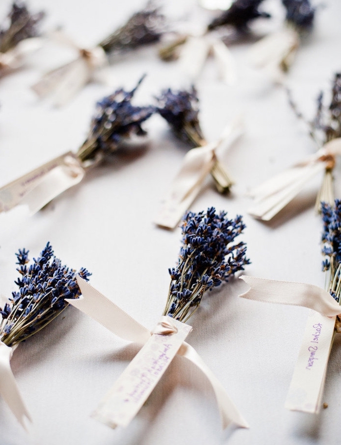 Kleine Zettel mit den Namen der Gäste an Lavendelsträußen befestigt, kleine Dekobänder