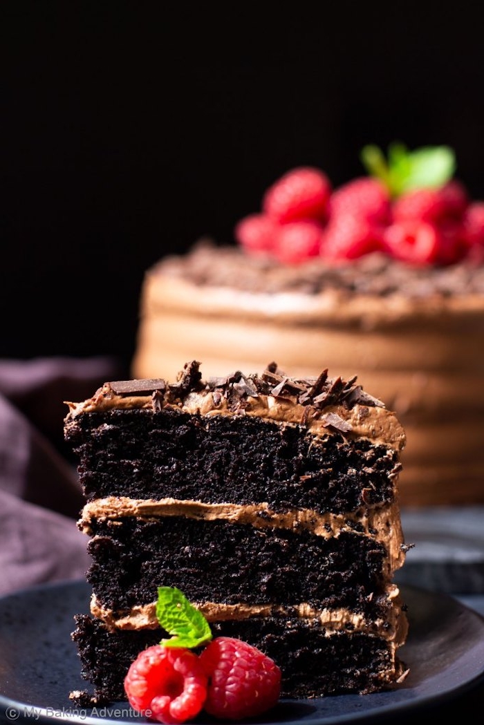 Dreistöckige Torte mit Schokoladencreme und Schokoladenstreuseln, dekoriert mit Himbeeren und Minze