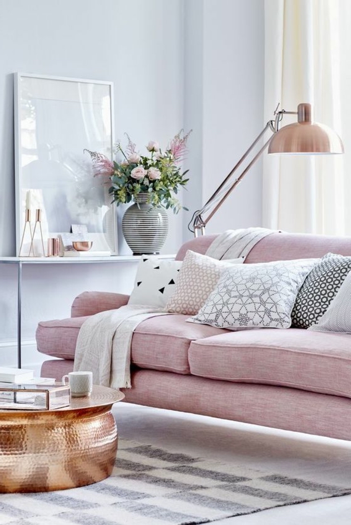 wohnzimmer wandfarbe, rosa sofa, dekokissen mit geometrischen motiven, gestreifte vase mit blumen, kupferfarbener tisch