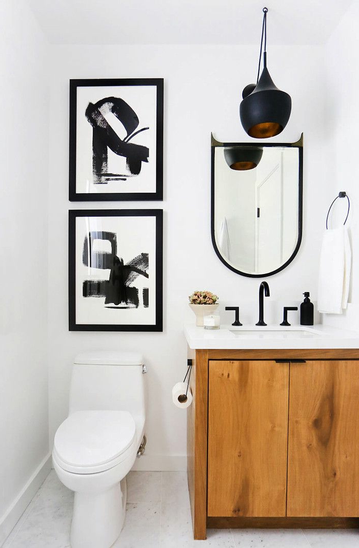 zwei Bilder mit schwarzen Figuren, ein Spiegel mit ausgefallener Form, Badmöbel Set aus Holz, schwarze Lampe, Badezimmer einrichten