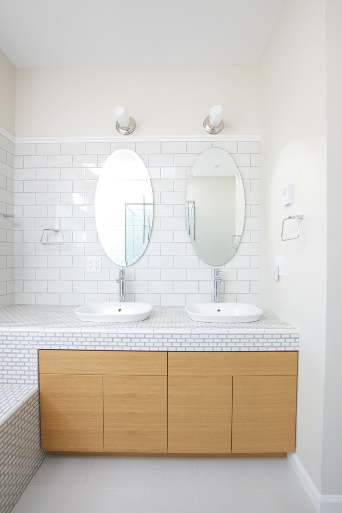 zwei Spiegel mit Waschbecken, Unterschränke aus Holz, weiße Fliesen an der Wand, Badezimmer einrichten