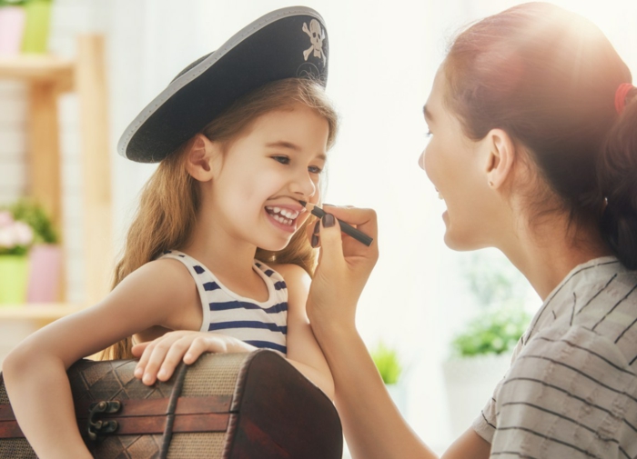 ein Mädchen spielt mit Ihrer Mutter, Mädchen Piratenkostüm, ein Spielzeug Schatzkiste, Halloween Verkleidung