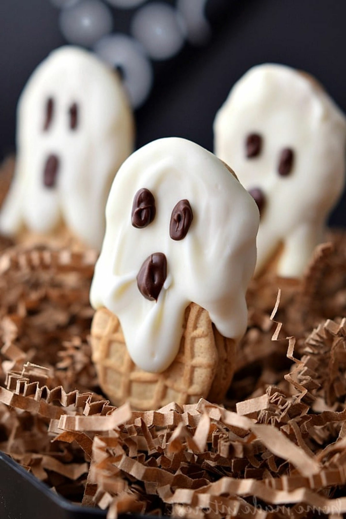 Gespenster mit weißer Creme und Schokoladen Augen und Mund, auf Kekse, Halloween Snacks